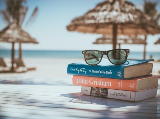 black framed Ray-Ban Wayfarer sunglasses on top of book