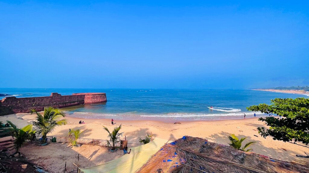 Candolim beach shore with blue ocean water under blue sky during daytime